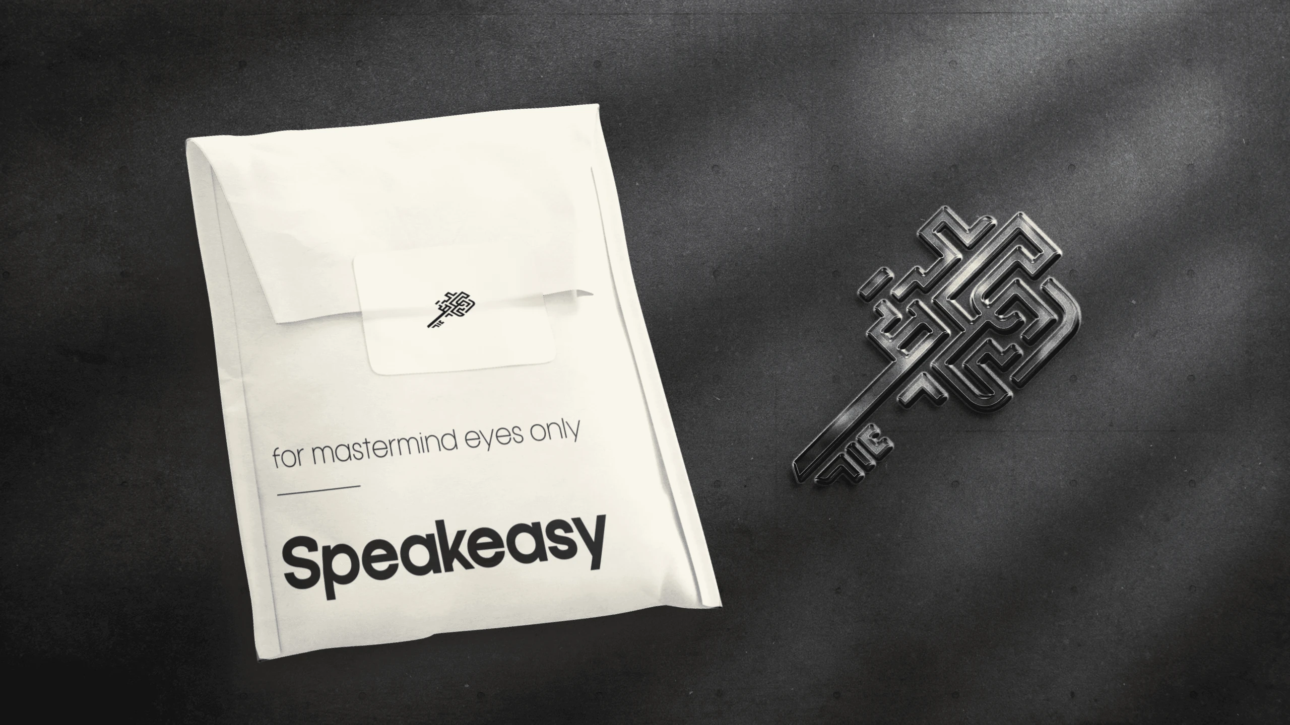 A cream envelope printed “for mastermind eyes only” beside a metal key whose head is cut as the Speakeasy maze monogram.