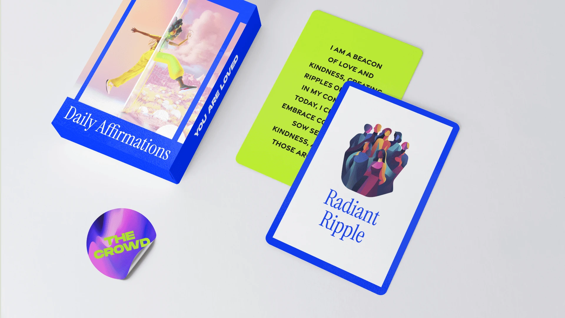 A Daily Affirmations card box, a “Radiant Ripple” card, a lime affirmation card and a holographic The Crowd sticker.
