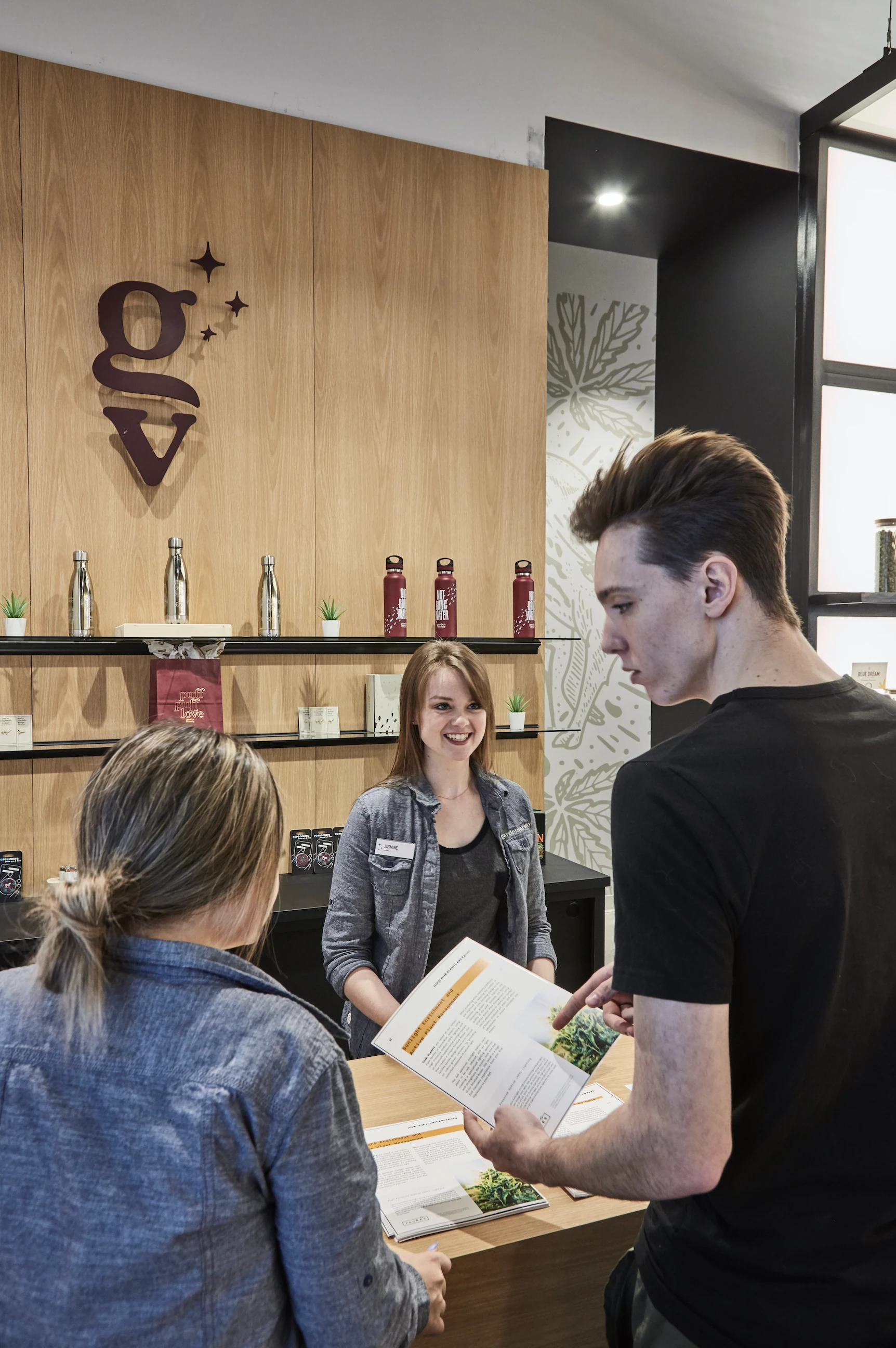 A customer being shown two jars at the wooden counter, the Sparwolf on the wall behind